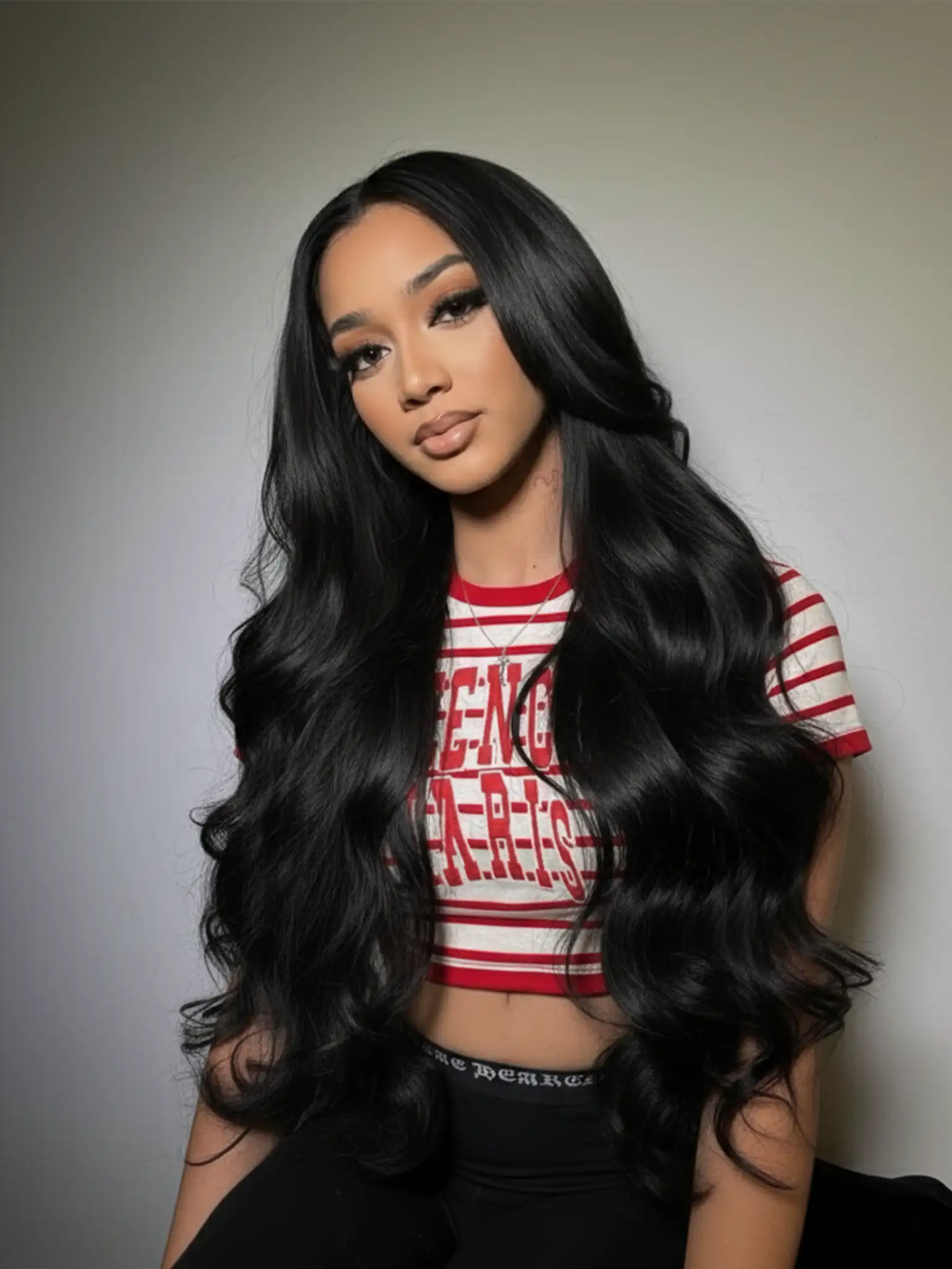 Femme portant des extensions adhésives Carthair Virgin Hair 12A Body Wave, longues, brillantes et au rendu naturel.