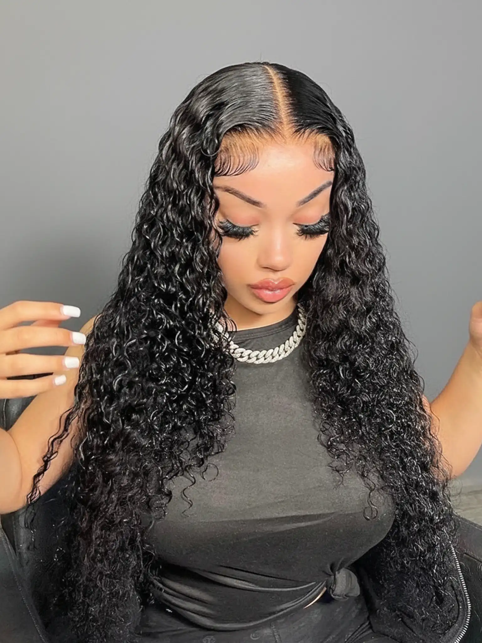 Femme portant des extensions adhésives Carthair Virgin Hair 12A Jerry Curly, boucles serrées et brillantes au rendu naturel et volumineux.