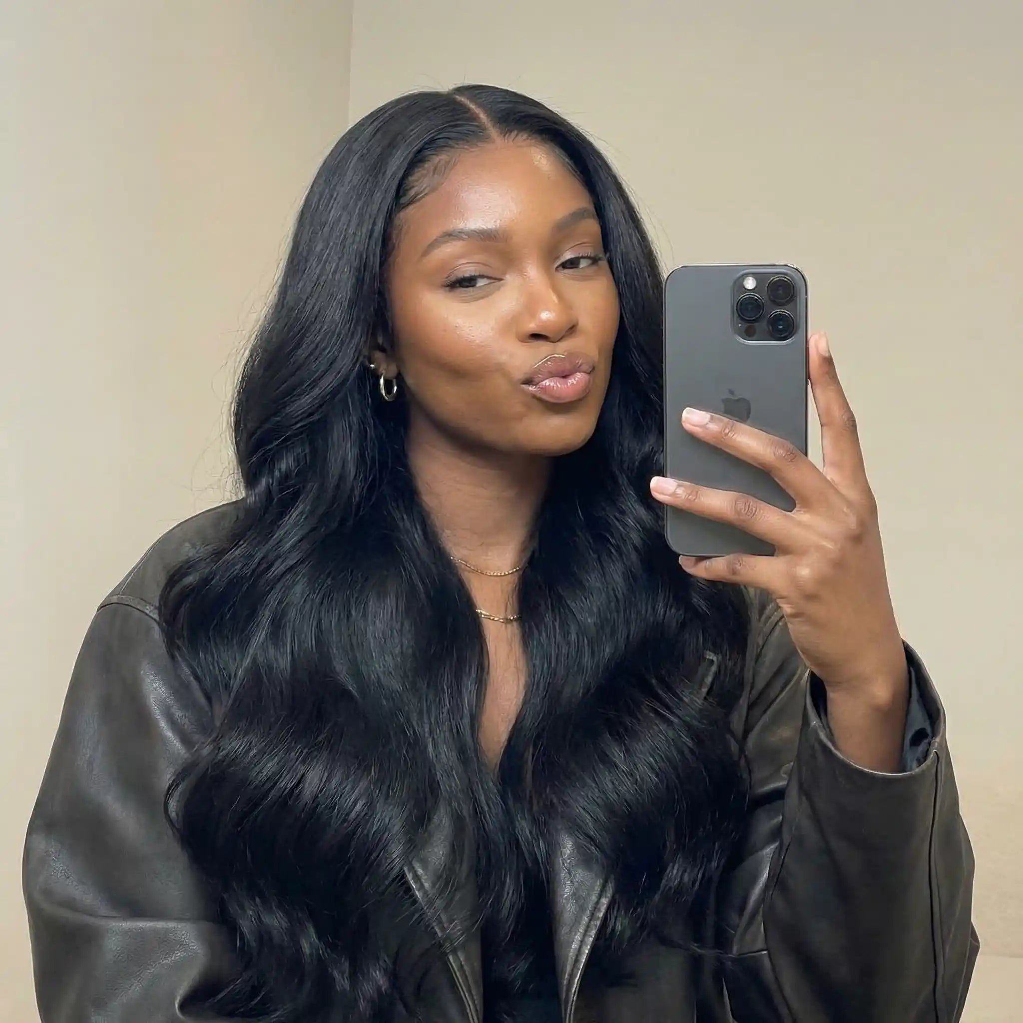 Femme noire portant une perruque raw hair noire longue avec ondulations naturelles et volume, selfie style Instagram.